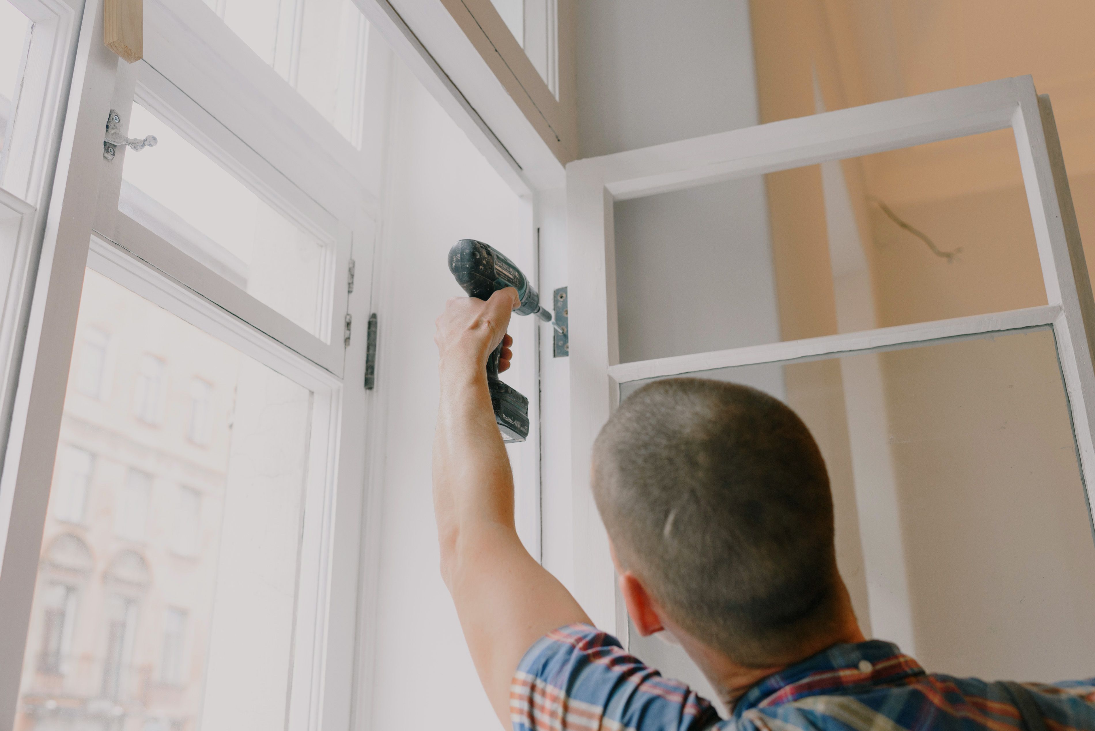 Contractor installing a window shutter